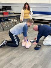 Mohawk Avenue School nurse Julie Richman watches PE teacher Kyle Markovich, left, and security guard Keith Hannam do a CPR drill. (Photo provided)