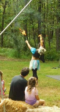 A fire-eating faery performs