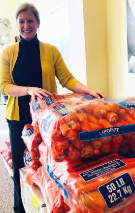 Kate McNamara stands with some of the produce donated by her family.
