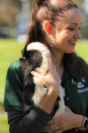 Kim Gruning, with Eyes of the World, holds Oliver, a North American Striped Skunk.