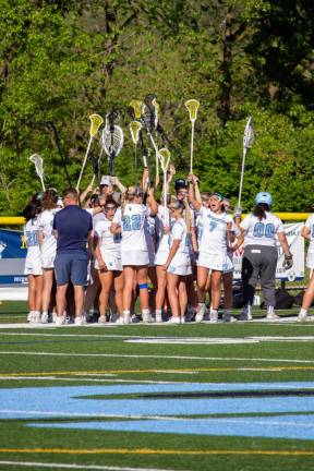 The Spartans raise their sticks during a time-out huddle.