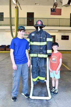 Sparta Township observes Fire Prevention Week Matt and Colin Reilly of Sparta pose next to a fireman’s gear.