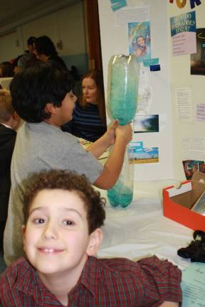Scientists of tomorrow shine forth Danny Mawhinney and his Tornado in a Bottle with classmate Aarau Kalmath who gives it a whirl.