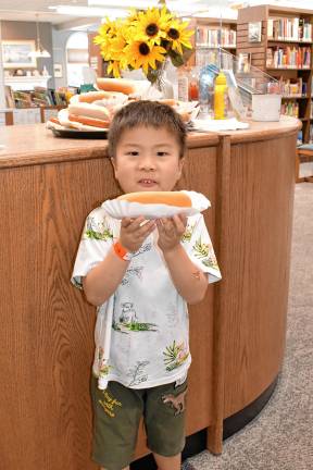 Sparta. Summer Reading Program begins SPL3 Tennyuu Tsui holds a hot dog at the kickoff events. (Photo by Maria Kovic)