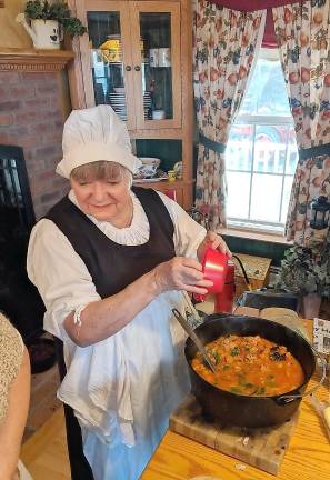 Open hearth cooking Una Lee serves soup to participants atthe Smoked Sausage Soup.