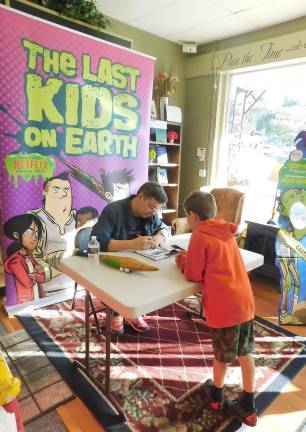 Max Brallier, author of the popular Last Kids on Earth series, signs a book for a young fan at Sparta Books on Tuesday, Sept. 17, 2019. The latest book in the series, The Last Kids on Earth and the Midnight Blade, was released that day, as well as the series premiere of a Netflix show based on the books.