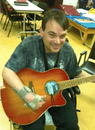 Jammin' for brain injury victims Scott Harris, former Wild West City cowboy and Byram native, with his guitar.