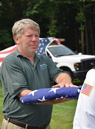 John Hatzells, retiring director of SCUMA, receives the U.S. flag during the flag retirement ceremony.