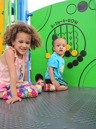 Inclusive playground opens CIP5 Anna Leah Burke, 5, and her brother Malachi, 1, playing 3-in-a-row. (Photo by Theresa Esposito)