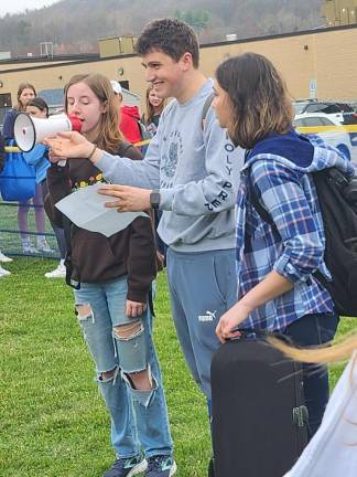 From left, seniors Annika Noel, Michael Rocco O’Krepky and Julia Juan read the names of victims of gun violence and cited statistics.