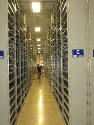 Thorlabs holds official opening The rows of shelves dwarf the employees.