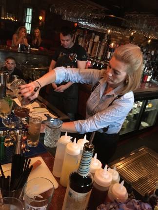 Claudineia Bock of the Bernards Inn pours a Manhattan, one of the required stirred cocktails