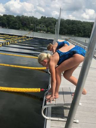 Tate Swenson (front) and her twin, Carly dive into the Sparta Pool. They are part of the swim team there and their mother, Tracey Swenson, is one of the coaches. Photo provided