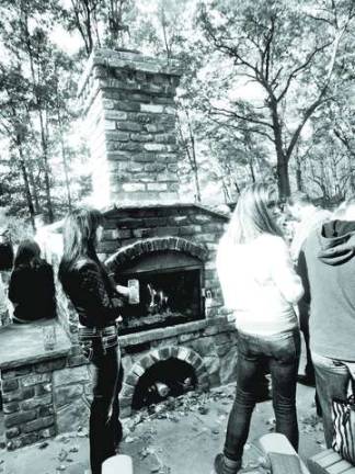 Guests gather around the outdoor fireplace to stave off the brisk fall air.