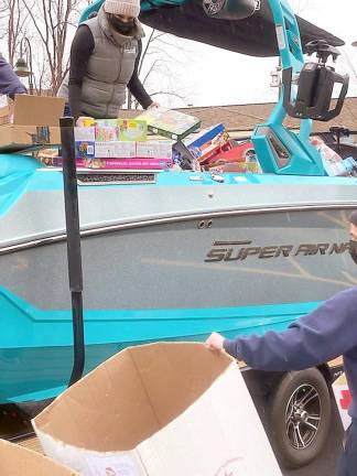 Staff unload toys from the boat delivered by Off Shore Marine to the Toy Shop at Project Self-Sufficiency (Photo by Laurie Gordon)