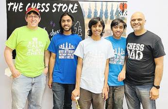 Akshat, Ayush, and Aneesh Iyer stand with ‘Chess Dads’ Michael Brawer and Venkat Iyer, who helped direct the tournament.