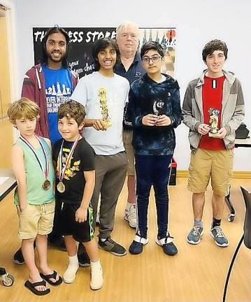 A few of the tournament winners show off their trophies, with Akshat Iyer and Sparta High School Chess Club Coach Tom Murray.