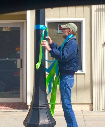 Green and blue ribbons herald Donate Life Month A volunteer carefully ties a blue and green ribbon around a lamp post on Spring Street in Newton. Photo by Laurie Gordon