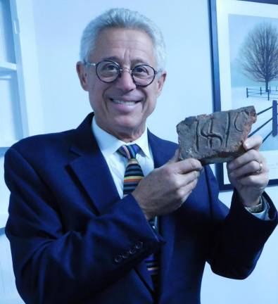 Attorney Mark Gruber shows off an original 1818 brick from the building he and his law partners have renovated from their former offices into a an office cooperative. Gruber toured guests around the building ahead of a rededication ceremony on Tuesday, Nov 12, 2019.