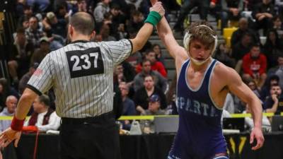 Spencer Stewart's hand is raised in victory as he secures his spot to compete at the State Championships.