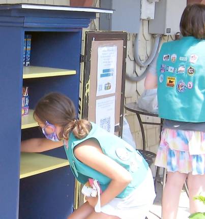 Girl Scouts from Troop 96251 diligently prepare pantry items for display.(Photo by Janet Redyke)