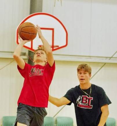 B.T. Basketball camp hosts practice Thirteen year old Grant Krueger of Hampton Township, is in the midst of a lay-up shot after getting past B.T. Basketball staff member Alex Podolski playing defense. Podolski is a graduate of Sparta High School where he played basketball.