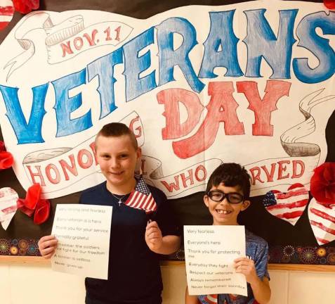 Philip Gely, left, and Zac Saul, right, prepare to present their poetry at the school's Veterans Day assembly