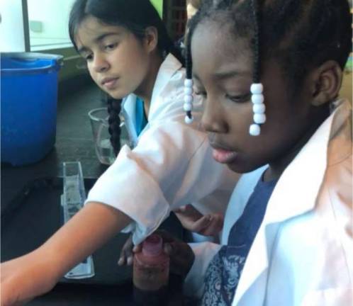 Melany and Aleciah work at a science experiment
