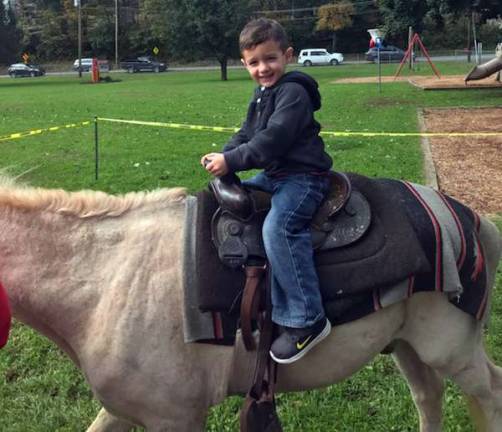 Three-year-old Tristan Stonebridge enjoys the pony rides. His grandpa works at the Stillwater School where the event was held.