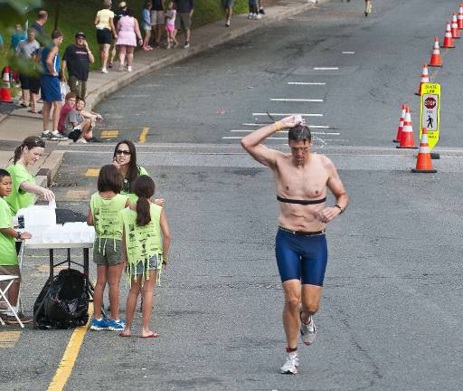 Triathlon draws athletes from 13 states Jim Holovacs of Sparta cools off with a water cup.