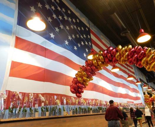 A giant U.S. Flag lines the wall as shoppers enter the supermarket.