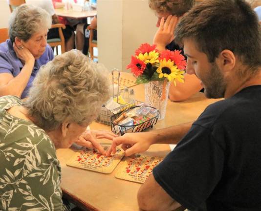 Irene Smith and Nick Broccoletti play Bingo together during the Sparta High Senior Football visit.