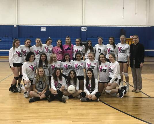 Haley Ward (right), Project Self-Sufficiency, receives a donation for the agency’s breast health education program from the members of the Pope John Women’s Volleyball Team.