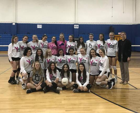 Haley Ward (right), Project Self-Sufficiency, receives a donation for the agency’s breast health education program from the members of the Pope John Women’s Volleyball Team.