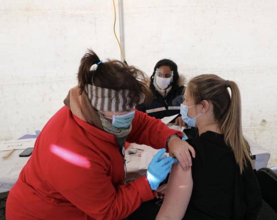 COVID-19 vaccine eligibility differs, depending on your state Mary Pat Bailey, a RN with Horizon Family Medical Group, administers a vaccine to Dental Assistant Kristy Castro of Pine Bush.