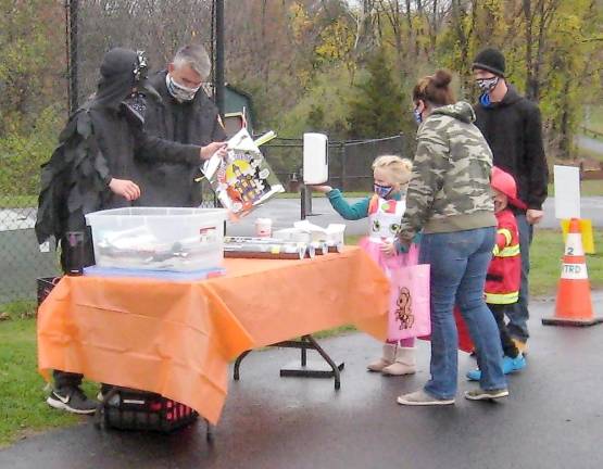 Trick or treating families visit the Treat or Trail tables in Maple Grange Park (Photo by Janet Redyke)