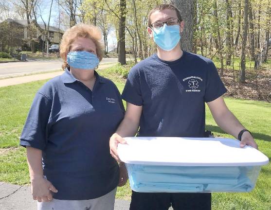 Stanhope Mayor Patricia Zdichocki (left) makes and donates disposable gowns for Stanhope Netcong American Legion Ambulance Squad with the help of Stanhope residents Maria Grizzetti, Diana Anthony, and Maureen Kurtz. Fifty gowns were presented to ambulance squad Captain Derrick Kuncken (right). (Photo provided)