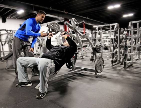 Passion for exercise serves as impetus for Alpha Fitness Anthony helping to guide a patron.