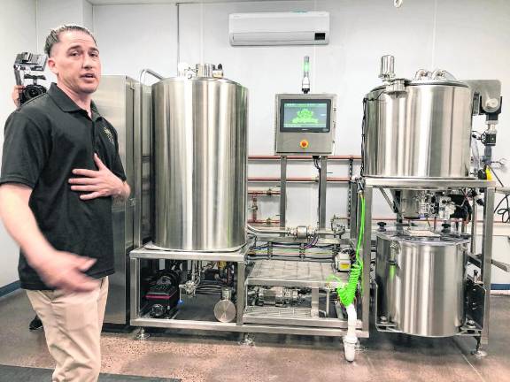 Seth Brown, director of manufacturing, gives a tour of the processing machines after the grand opening Thursday, March 14.