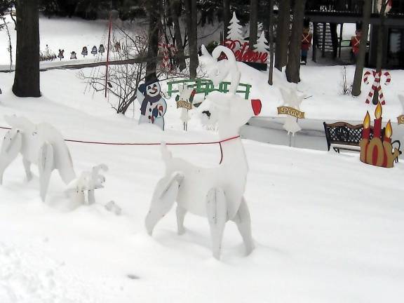 Wood cutouts of Rudolph and Santa created by John decorate the Westermajer front lawn (Photo by Janet Redyke)