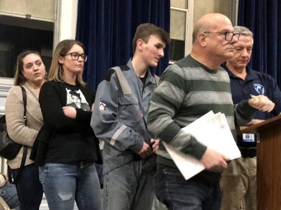 Chad Wood, center, the student representative to school board, waits to talk during the public comments.