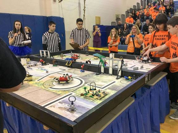 Newton Robotics hosts FIRST Lego League Qualifiers event Lafayette Middle School Team "Robot Rebels" competing on the field