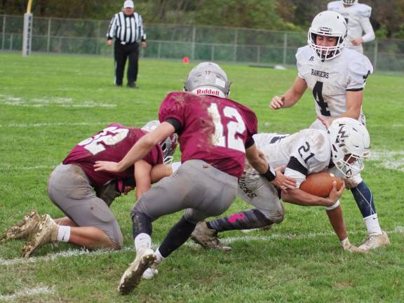 (Photos by George Hunter). Wallkill Valley ball carrier Justin Rivera is grabbed by Newton defenders in the second half.