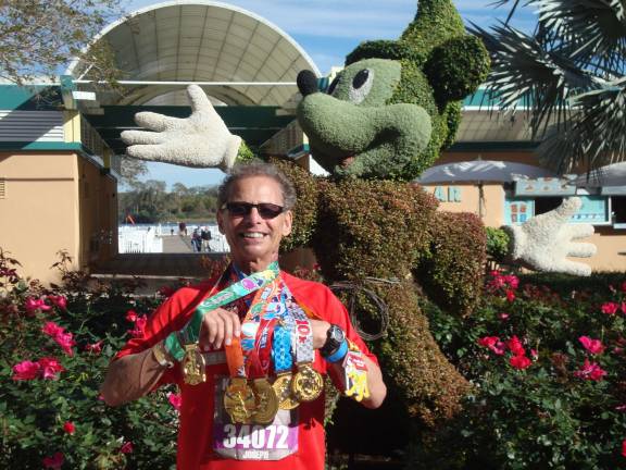 Joseph Farinella, 75, of Andover shows off his six medals for completing Disney World's Dopey Challenge.