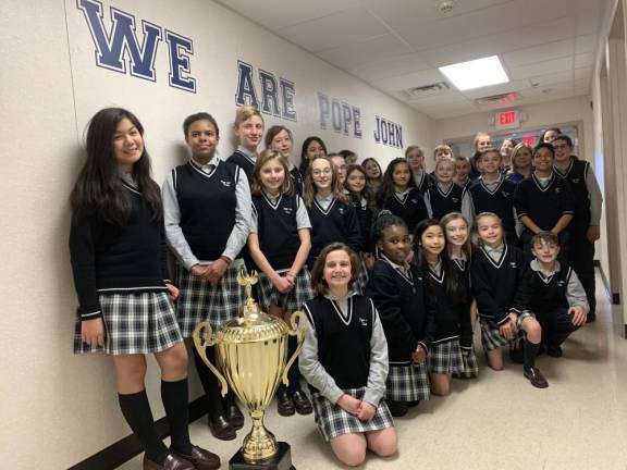 Pope John XXIII Middle School's leadership council poses for a photo with the Stuff the Stocking trophy in the school's hallway on Thursday, Jan. 16, 2020, in Sparta. Pope John XXIII Middle School won the trophy for the third straight year after donating a record 958 toys to Project Self Sufficiency's sixth annual toy drive competition.