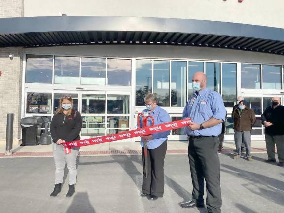 Store manager Amy Zimmerman with two employees get ready to cut the ribbon at the Market Community Day Celebration in Dingmans Ferry (Photo by Marilyn Rosenthal)