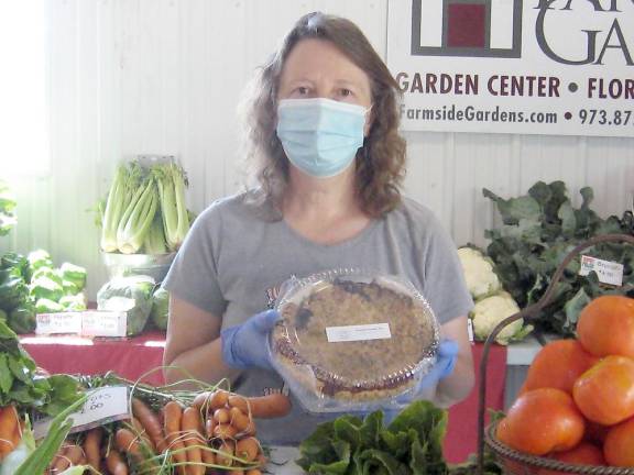Nine local farms sell their wares at fairground farmers market Market organizer Donna Traylor displays one of the delicious pies at the market. (She’s actually smiling behind her mask, BTW.) (Photo by Janet Redyke)