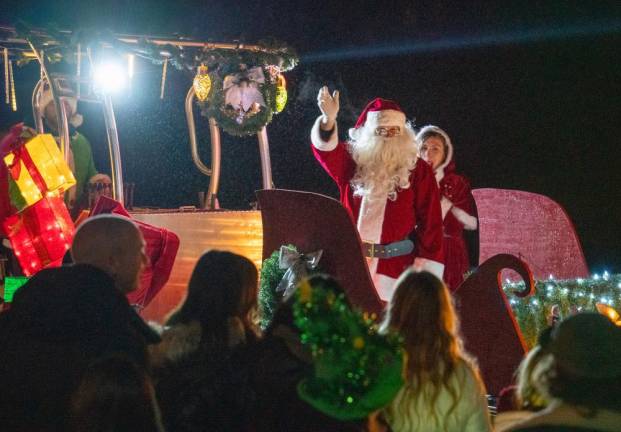 LM2 Santa waves at the crowd. About 100 people waited for the arrival of Santa and Mrs. Claus at the Lake Mohawk Boardwalk, where he lit the Christmas tree.