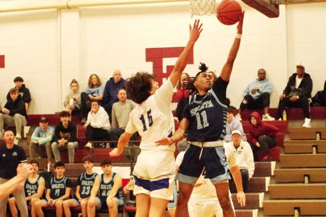 SB1 Sparta's Leshem Little (11) takes the ball toward the hoop while Warren Hills defender Jake Nisivoccia tries to stop the shot. Little scored eight points in the championship game of the Newton Holiday Tournament. Sparta won, 48-43. (Photos by George Leroy Hunter)