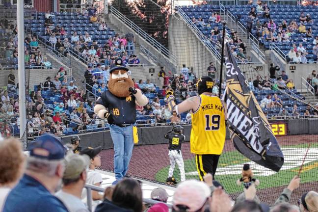 Miners lead division <b>Herbie the Miner and Miner Man perform in front of baseball fans.</b>